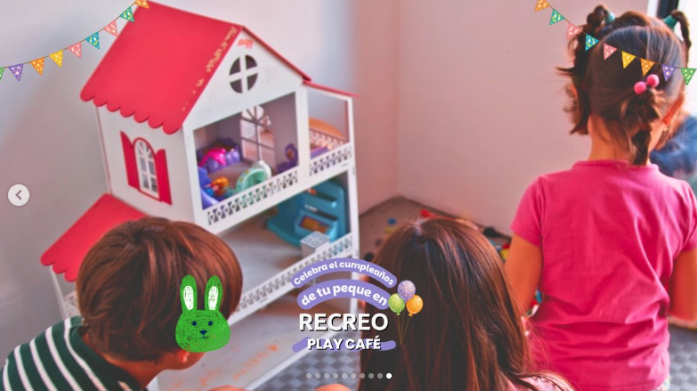 Niñas jugando con una casa de muñecas en la sala de juegos